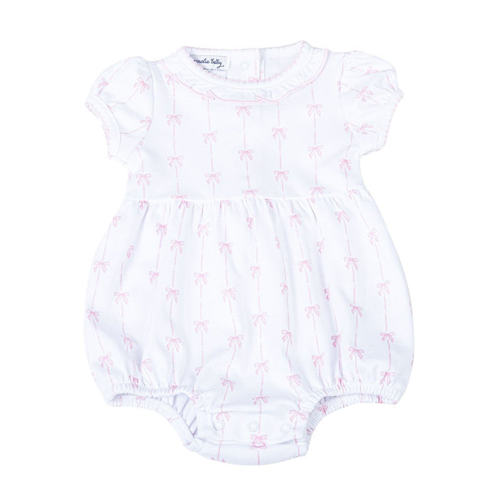 White baby bubble romper with pink bow print, short sleeves, gathered legs, and snap closure displayed on a white background