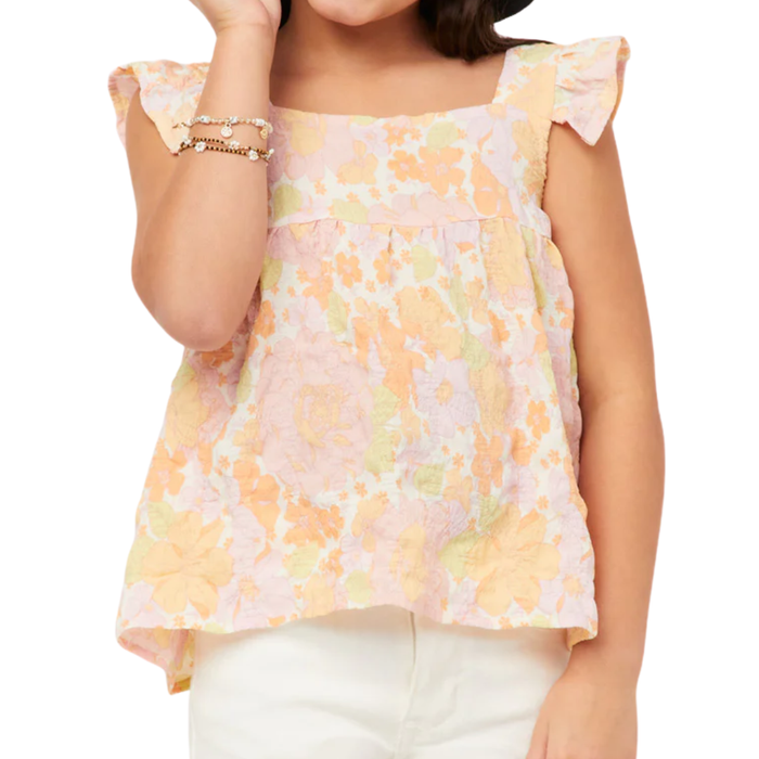 Tween girl wearing a pastel floral ruffle sleeve tank top with soft peach and yellow flowers and flowy fit.