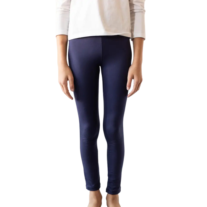 Girl wearing solid navy blue fitted leggings with a white long-sleeve top against a white background.