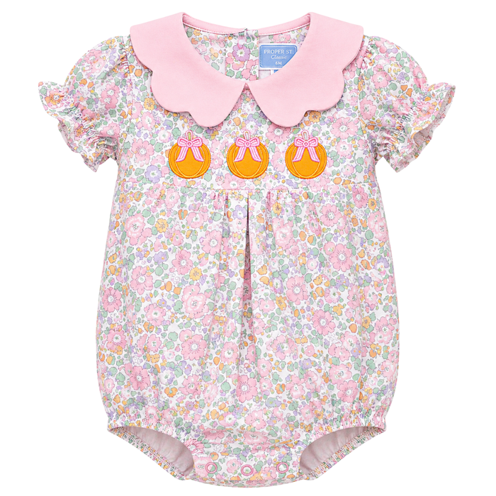 Baby girl floral bubble with embroidered pumpkins, pink scalloped collar, and ruffle sleeves in pastel floral print.