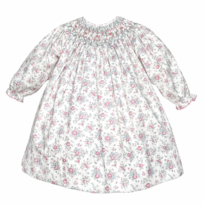 Girls ivory floral dress with pink and blue flowers, a smocked neckline, long puff sleeves and ruffled elastic cuffs.