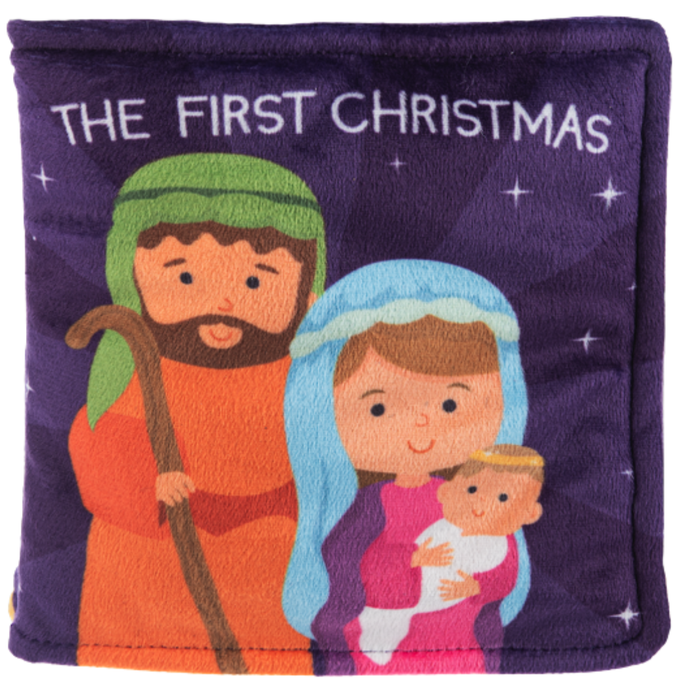 Soft baby book featuring nativity scene with Mary, Joseph, and baby Jesus titled “The First Christmas.”
