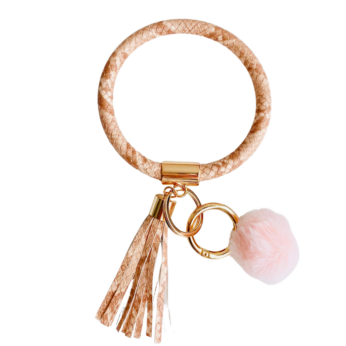 orange snake skin bangle with a pink pom pom and orange snake skin fringe
