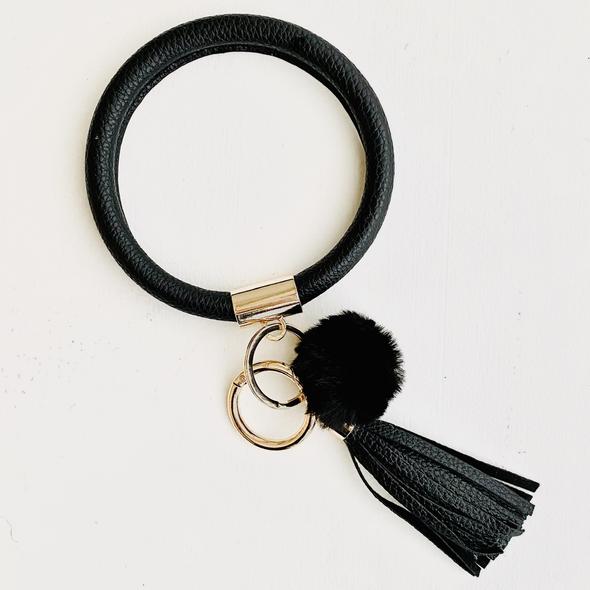 solid black bangle with a black pom pom and a black fringe