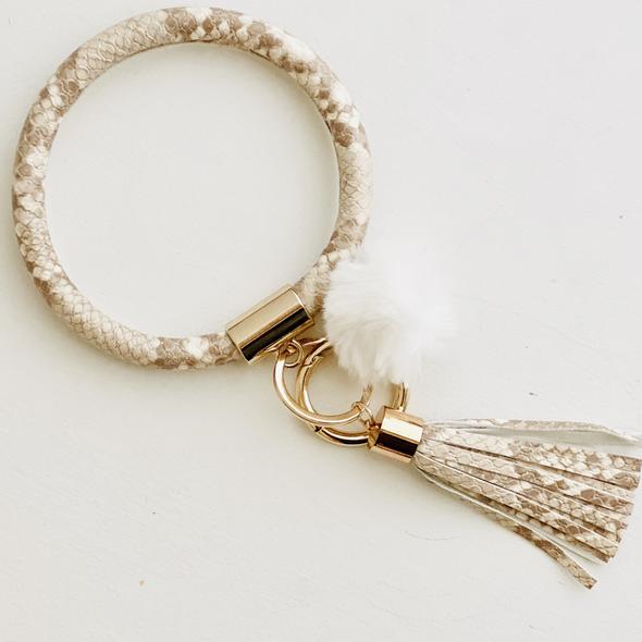 cream and brown snake skin bangle with a white pom pom and a cream and brown fringe