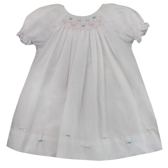 White dress smocked with roses on the hemline.