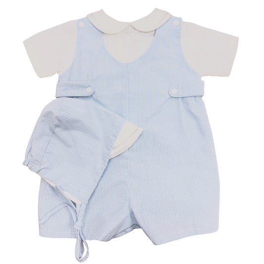 Baby boy blue micro check romper worn over white collared shirt with matching bonnet, photographed on a white background.