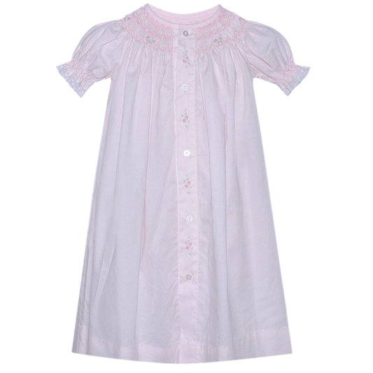 Baby girls pale pink smocked bishop style daygown with embroidered floral details and puff sleeves on white background