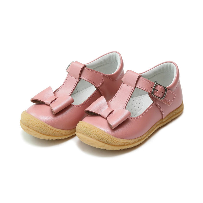 Pink mary jane velcro shoe with an accent bow on the front