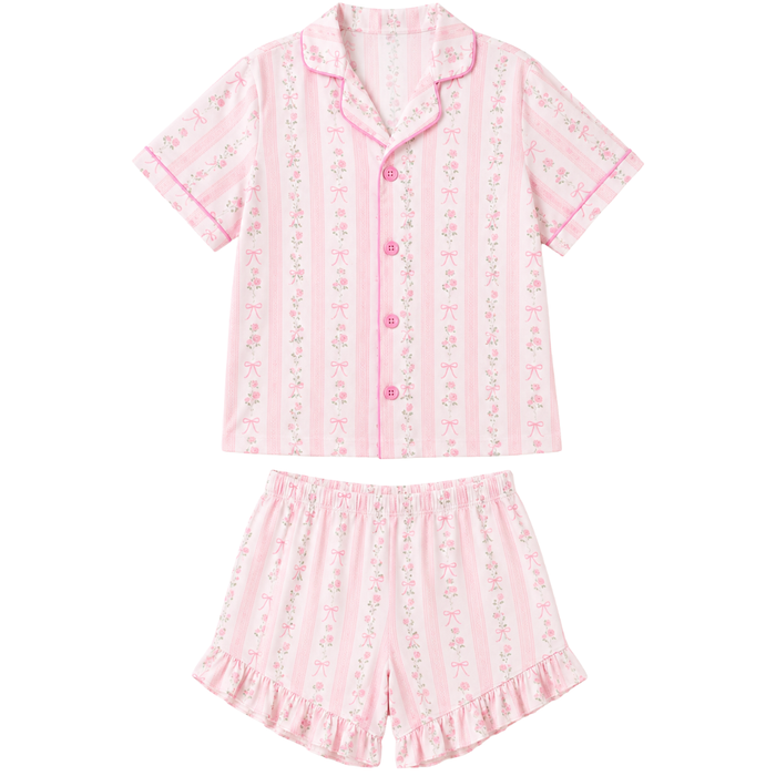 Girls’ pink and white pajama short set featuring floral stripes, bow details, a button-down collared top, and ruffled shorts.