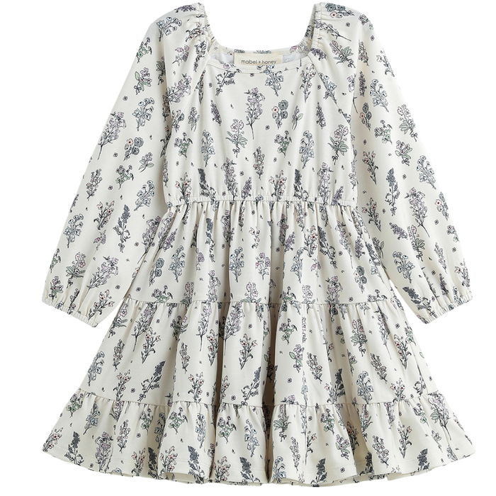 Girls cream floral long sleeve tiered dress with soft vintage print on a white background.
