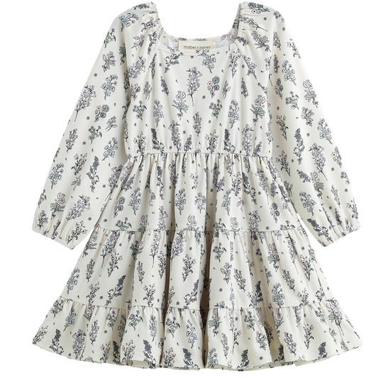 Girls cream floral long sleeve tiered dress with soft vintage print on a white background.
