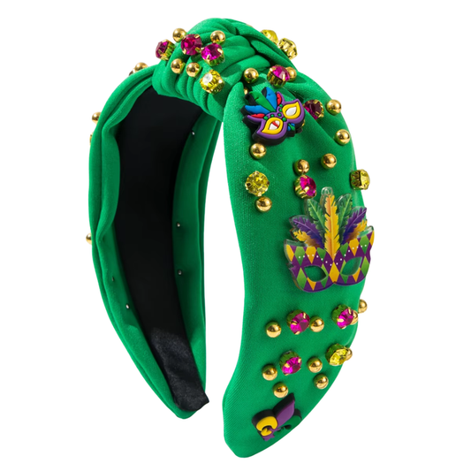 Green Mardi Gras knot headband decorated with gems, gold studs, and festive mask and feather embellishments.