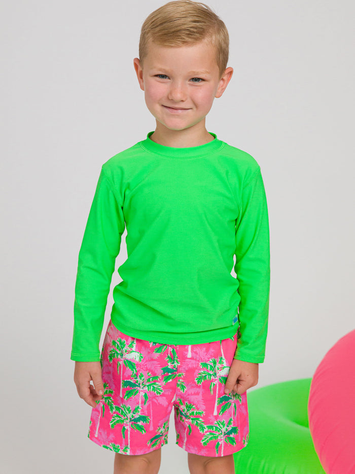 boy wearing the lime green rash guard and colorful coordinating swim trunks
