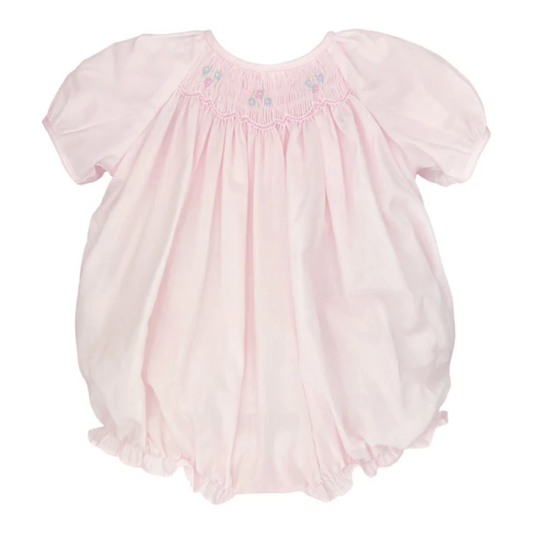 Baby girl pink smocked bubble romper with puff sleeves, hand-smocked neckline, and snap bottom on white background.
