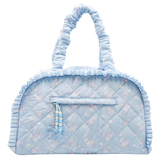 Light blue quilted floral duffle bag with ruffle trim, padded handles, and decorative zipper charm