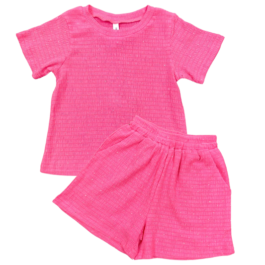 Pink children's outfit with top and shorts on a white background