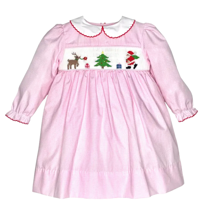 Girls pink gingham Christmas dress with smocked Santa, reindeer, tree and gifts, plus a white Peter Pan collar and long sleeves.