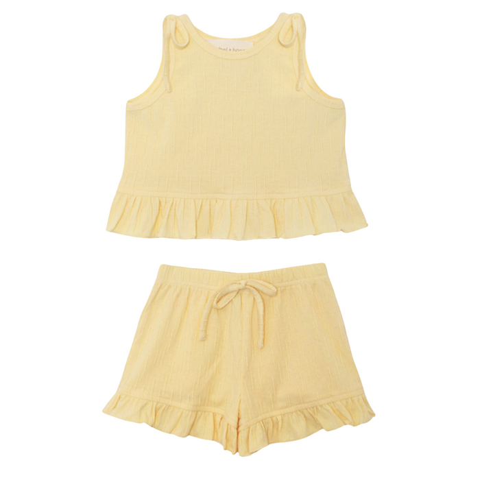 Butter yellow ruffle top and short set for girls with textured fabric on white background