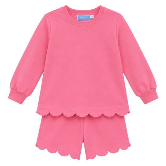 Girls pink two-piece set with long sleeve top and scalloped hem shorts, featuring soft fabric and a relaxed fit.