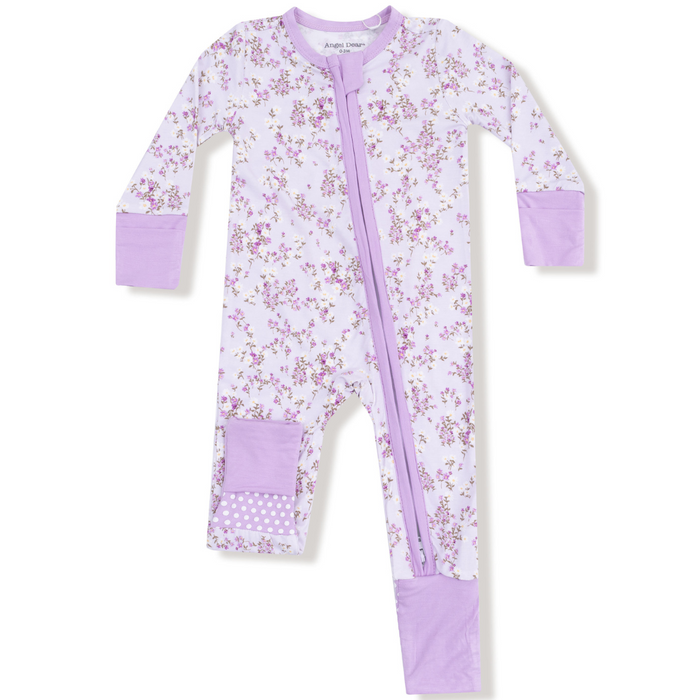 Lavender baby romper with allover floral print, lilac trim, and contrasting lavender foot and leg patches featuring polka dot accents.