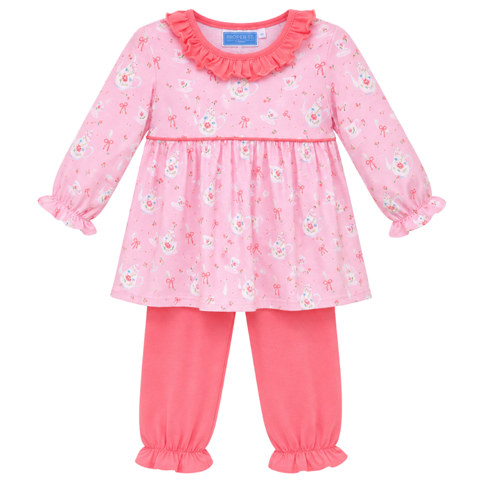 Girls pink two-piece outfit with teacup and bow print, featuring a ruffle neckline top and matching pants with ruffle hems.