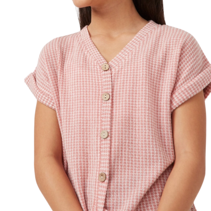 Tween girl wearing a pink waffle knit button front top with rolled sleeves and textured fabric.