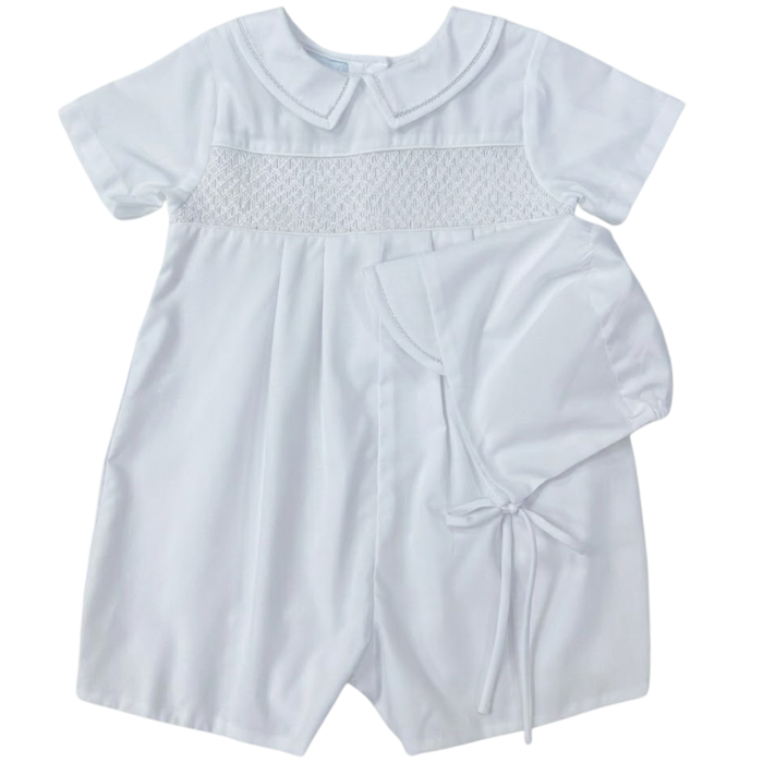White baby romper with smocked details on a white background